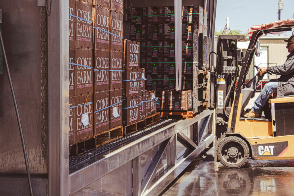 Boxes of produce at Coke Farms Food Hub processing center being moved by forklift and employee. CCOF staff tour July 2024. Photo by Christina Adams, Graphic Designer.