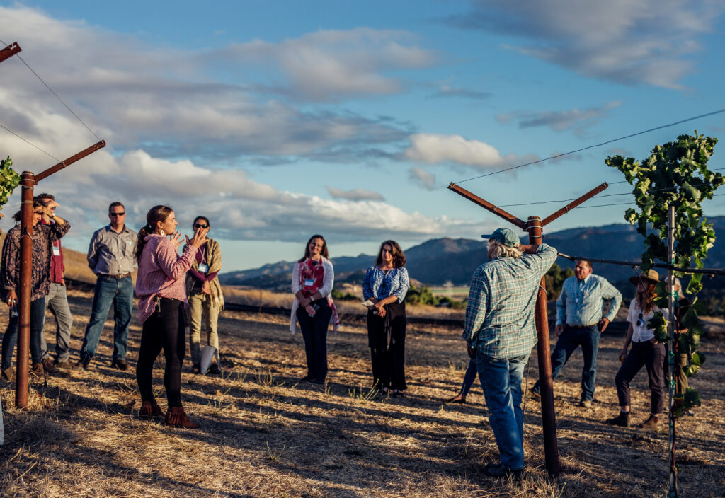 CCOF CEO Kelly Damewood speaking to a group of farmers and employees during tour of organic vineyard